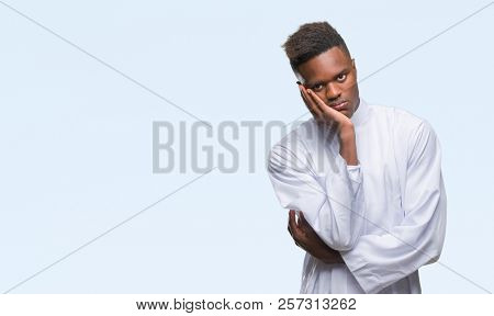 Young arabic african man wearing traditional djellaba over isolated background thinking looking tired and bored with depression problems with crossed arms.