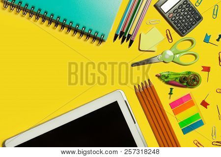 Various School And Office Suplies And Gadgets Lying On A Yellow Background. Free Space For Text