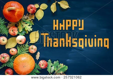 Happy Thanksgiving Text With Pumpkins And Leaves Over Dark Wood Background