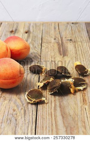 Apricots And Apricot Stones On Wooden Table