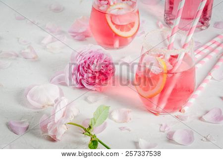 Summer Refreshment Drinks. Light Pink Rose Cocktail, With Rose Wine, Tea Rose Petals, Lemon. On A Wh