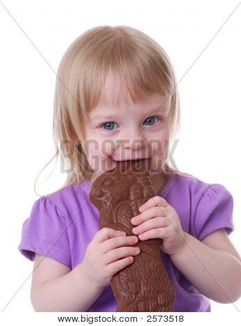 Liten flicka äter en choklad påskharen