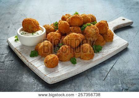 Homemade Breaded Garlic Mushrooms With Sour Cream And Parsley On White Wooden Board