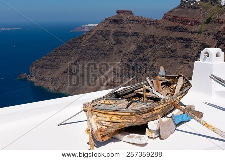 Old Wooden Broken Boat On Roof Of House, Located At Santorini Island, Greece