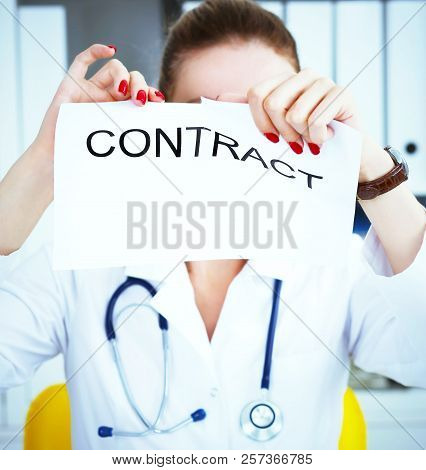 Hands Of Female Medicine Doctor Ripping Contract. Photo With Depth Of Field.