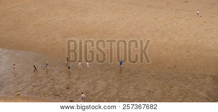 Children Playing Happily On The Beach At King Edward's Bay Seen From A High Viewpoint.