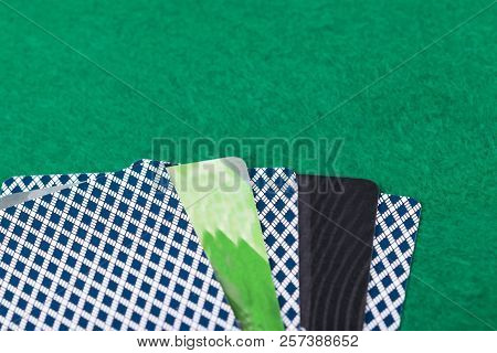 Plastic Bank Cards Lie With Cards For Playing Poker On The Green Table Cloth