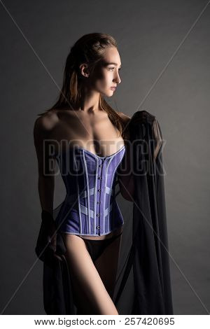 Slim Brunette In Corset In The Dark Profile View