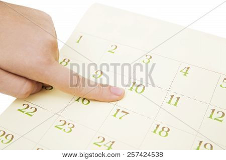 Female's Finger Showing Date In A Calendar On White Background. Number In The Calendar