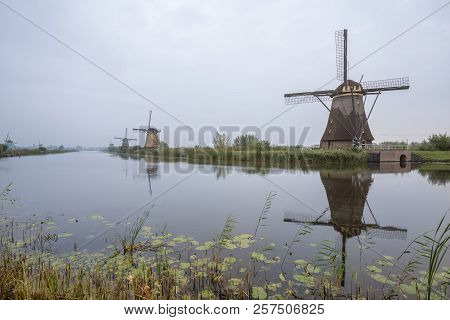 On The Water There Are Several Windmills In Kinderdijk In Holland