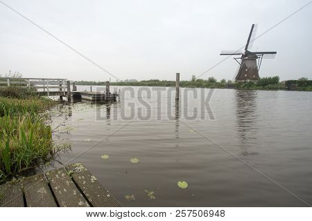 On The Water There Are Several Windmills In Kinderdijk In Holland