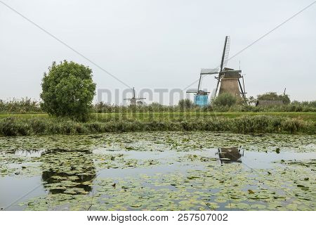 On The Water There Are Several Windmills In Kinderdijk In Holland