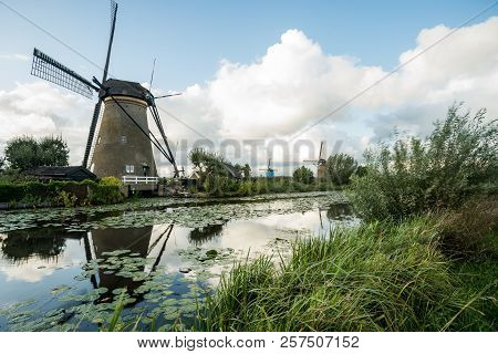 On The Water There Are Several Windmills In Kinderdijk In Holland