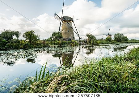 On The Water There Are Several Windmills In Kinderdijk In Holland