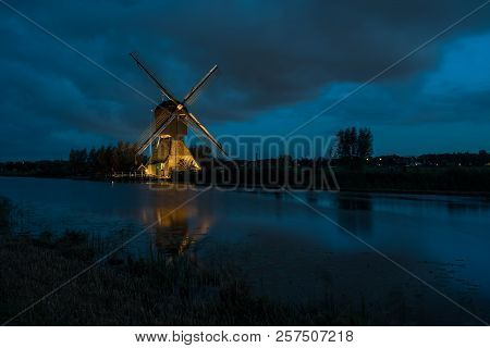 These Beautiful Windmills In Kinderdijk Are Illuminated With White Light At The Blue Hour