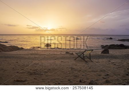Beach Chair On The Sand With Sunrise Sky