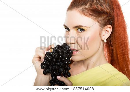 Beautiful Redhead Woman Is Eating Black Grapes. Concept Of Healthy Eating