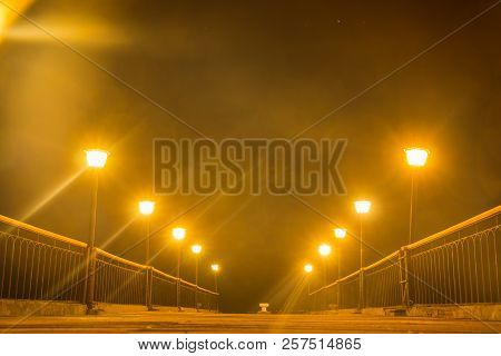 The Lights Ging Off Into The Distance In A Foggy Night