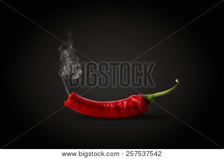 Red Hot Chilli Pepper With Smoke Coming Out Of It. Dark Black Ba