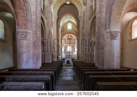 Gourdon, France - August 3, 2018: Interior With Pink Color, Wooden Benches And Huge Pilars Of The Ro