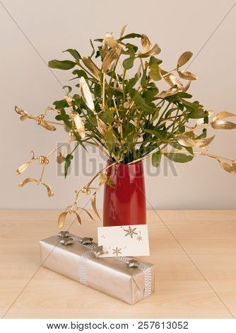 Gift In Silver Package With Mistletoe In Vase