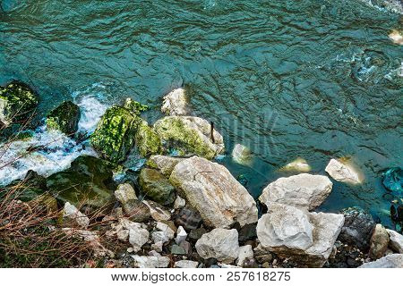 Rocky Sea Shore And Blue Water. River Flowing Among Mossy Stones. Seascape, Coastline, Rocks On Wild