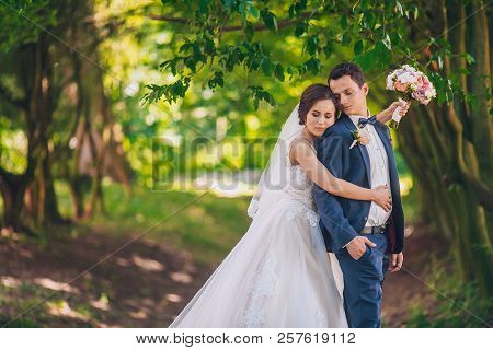Romantic Wedding Moment, Couple Of Newlyweds Smiling Portrait, Bride And Groom Hug While On A Walk I