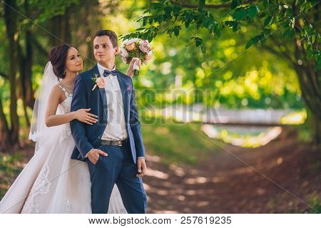 Romantic Wedding Moment, Couple Of Newlyweds Smiling Portrait, Bride And Groom Hug While On A Walk I