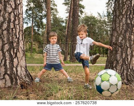 Children Playing Soccer Outdoor. Boys Playing Soccer In The Park. Two Kids Kicking The Ball At The Y