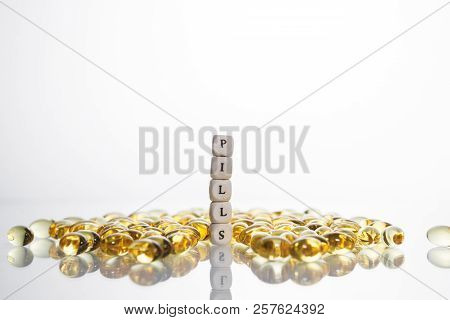 Word Pills From The Letters Of Cubes And Lecithin Gel Pills On Light Background. Soy And Sunflower L
