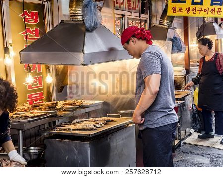 Seoul, South Korea - June 21, 2017: Man Vendor Cooking Tasty Fried Fish On The Gwangjang Market In S