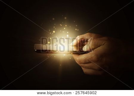 A Computer Tablet In The Hands Of A Man On A Dark Background With Neon Light, A Flash Of Light, Magi