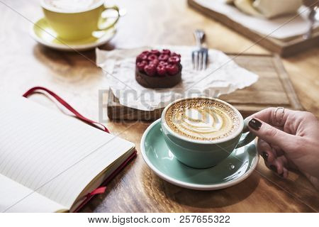 Having Lunch With Coffee Flat White And Sweet Chocolate Cookie In A Cafe Or Restaurant. Woman Hand H