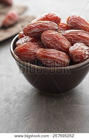 Fresh Medjool Dates In A Bowl. Ramadan Kareem. Black Background. Top View. Copy Space.