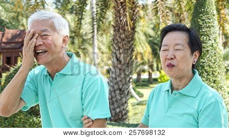 Happy Asian Elderly Couple Laugh Together In Green Natural Park Background
