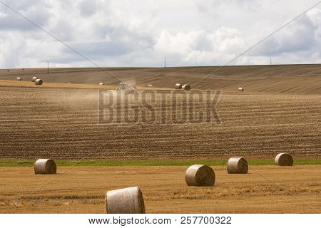 Straw Bales With Tractor On An Agricultural Grain Field In The Morvan, France.