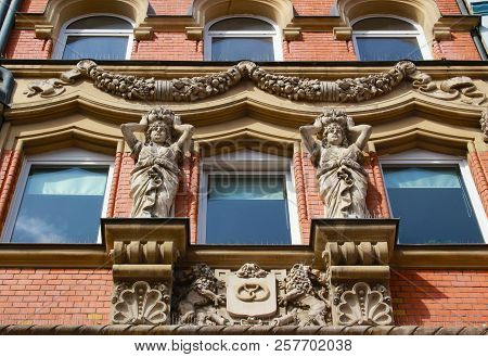 Facade From The Period Of Historicism With Female Figurines And A Garland