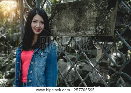 Model Woman Posing In Outdoor Nature With Advertising Woood Empty Board For Your Text.