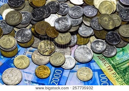 Russian Banknotes And Coins. A Handful Of Coins On New Russian Banknotes In Denominations Of 2000 An
