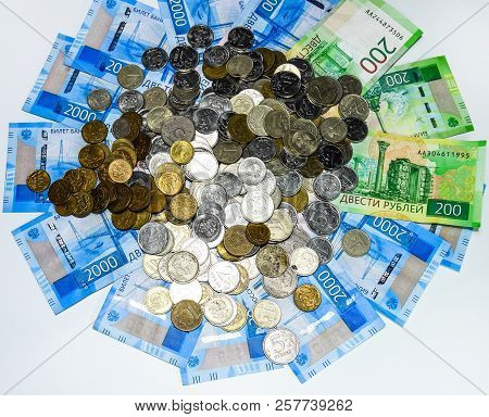 Russian Banknotes And Coins. A Handful Of Coins On New Russian Banknotes In Denominations Of 2000 An