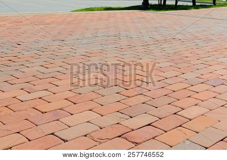 Pavement Of Red, Dark Red And Orange Bricks Beside Carriageway At Summer Day