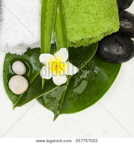 Two White Stowns On Green Leaves With Other Spa Objects