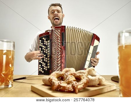 Man In Traditional Bavarian Clothes Playing Accordion. Germany, Bavaria, Upper Bavaria. The Young Ha
