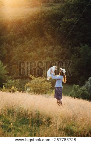 Girl In A Hat Playing With A Dog In The Field At Sunset Sun