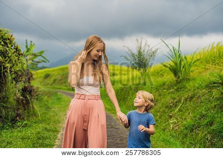 Mom And Son Travelers On Beautiful Jatiluwih Rice Terraces Against The Background Of Famous Volcanoe