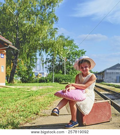 Adorable Little Girl On A Railway Station, Waiting For The Train With Vintage Suitcase. Traveling, H