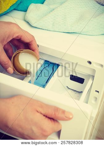 Washing Powder Detergent And Measuring Cup Pouring Into Machine. Household Duties, Clothes Laundry O
