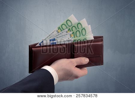 Businessman's hand in suit takes out eruo from his wallet