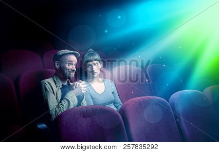 Teenager couple cuddling and watching the climax part of the movie