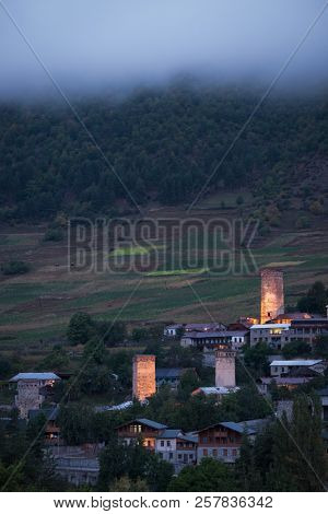 Night view of the city of Mestia. Medieval towers with illumination. Tourist attraction in the mountains. Caucasus, Georgia, Zemo Svaneti